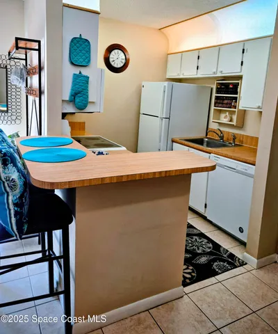 a kitchen with stainless steel appliances kitchen island a table chairs and a refrigerator