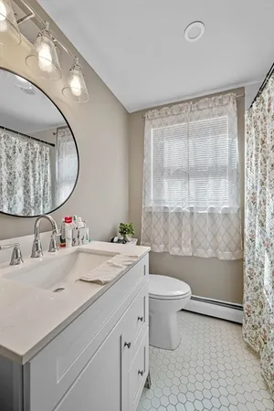 a bathroom with a sink a toilet and a mirror