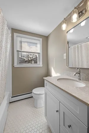 a bathroom with a granite countertop sink toilet and mirror