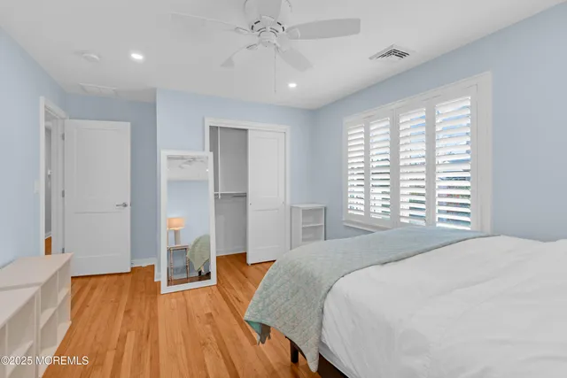 a spacious bedroom with a bed and a wooden floor