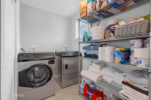 a utility room with dryer washer and a view of living room