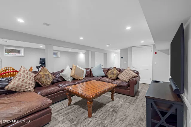 a living room with furniture a flat screen tv and a window
