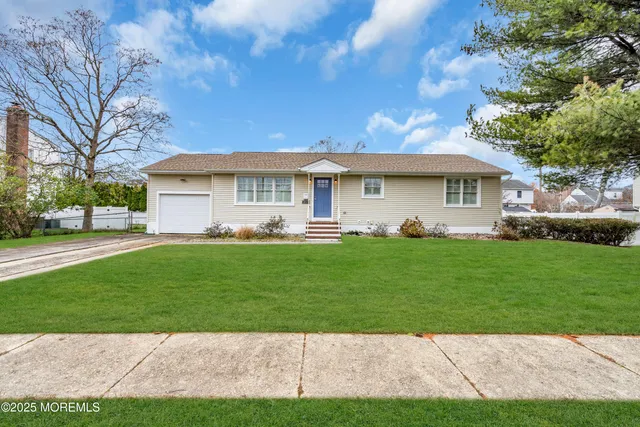 a front view of a house with a garden and trees