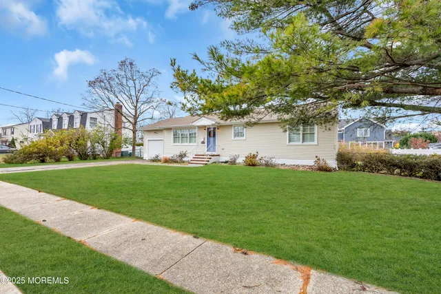 a front view of a house with a garden and yard