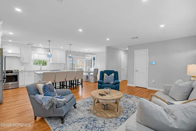 a living room with furniture and view of kitchen