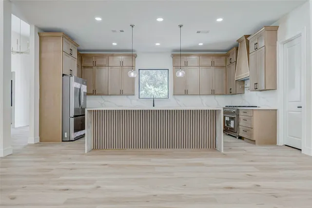 a kitchen with stainless steel appliances granite countertop a refrigerator and a sink