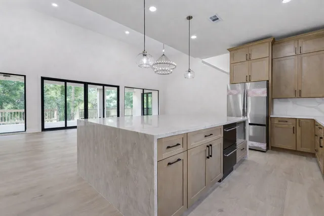 a view of an empty room with chandelier and fire place