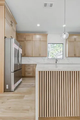 a kitchen with stainless steel appliances granite countertop a refrigerator and a sink