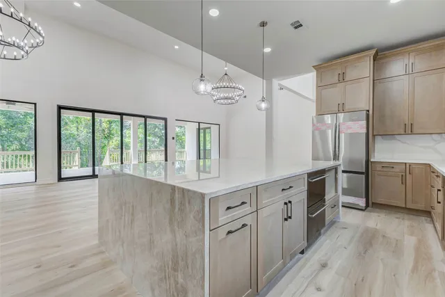 a large kitchen with stainless steel appliances a large counter top