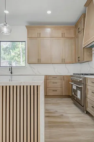 a kitchen with granite countertop white cabinets and wooden floor