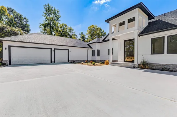a front view of a house with a garden and trees