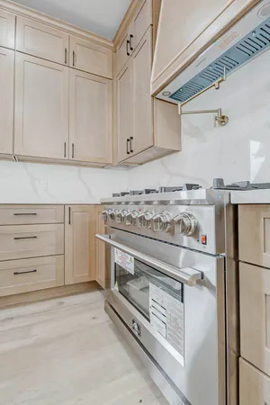 a kitchen with granite countertop white cabinets and wooden floor