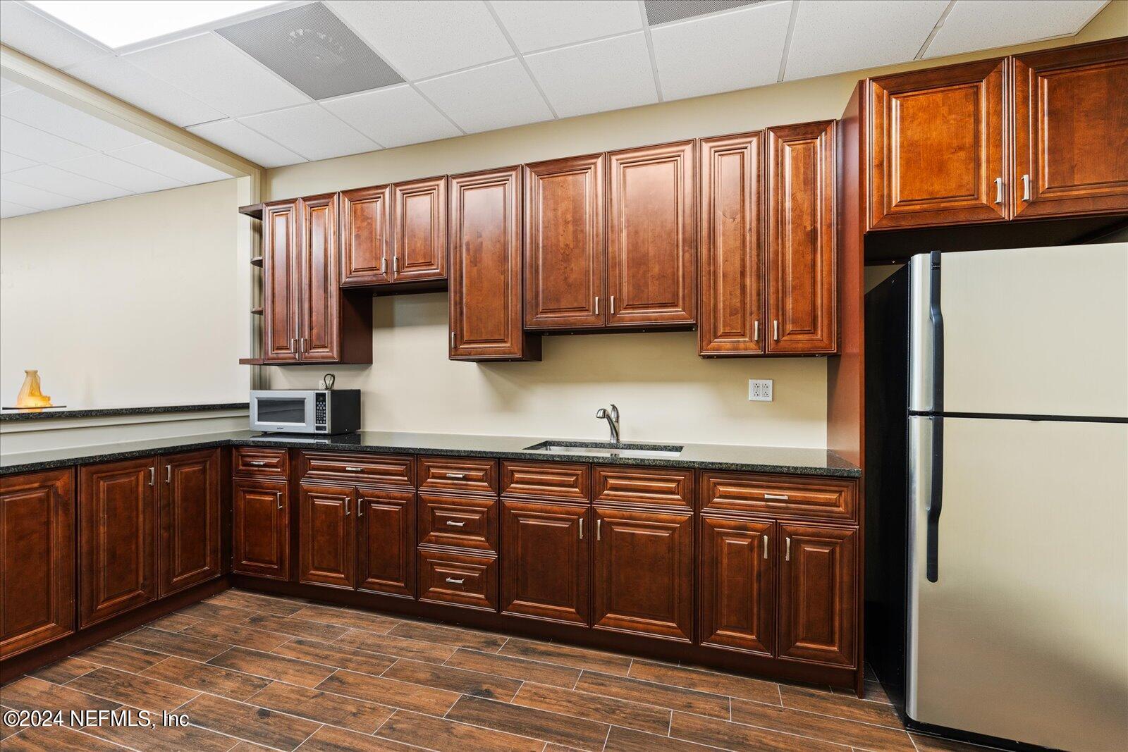 6255 Colbert Lane Flagler Beach, FL 32136 - Photo 12 of 16 a kitchen with stainless steel appliances granite countertop wooden cabinets a refrigerator and sink