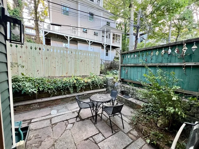 a view of a chair and table in backyard