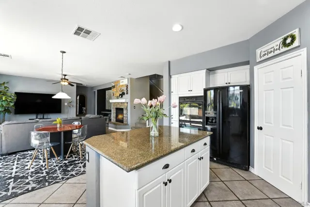 a kitchen with stainless steel appliances granite countertop a sink a refrigerator and a stove
