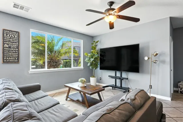 a living room with furniture and a ceiling fan