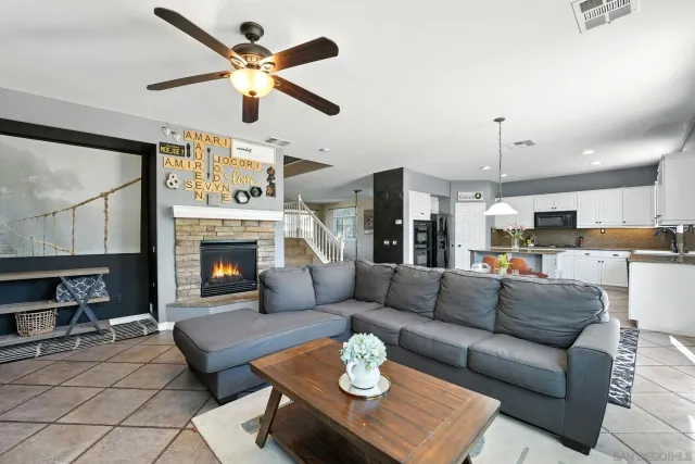 a living room with furniture ceiling fan and a window