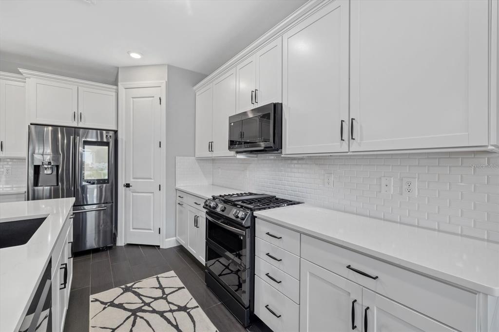 3508 Anchor Bay Trail Lakewood Ranch, FL 34211 - Photo 11 of 74 a kitchen with stainless steel appliances white cabinets and stove