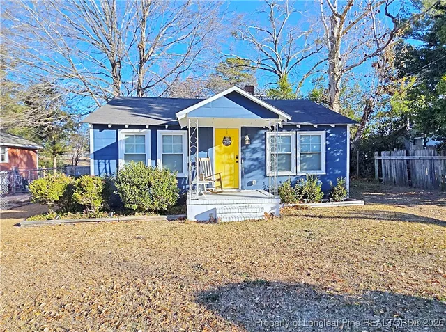 a front view of a house with a yard and potted plants