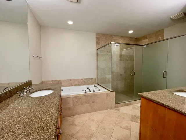 a bathroom with a granite countertop sink a toilet and shower