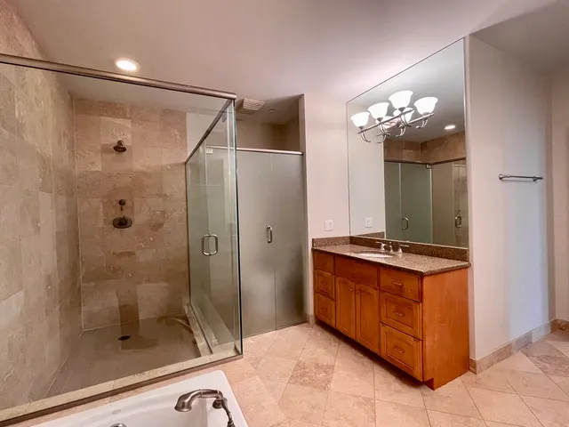 a bathroom with a granite countertop sink a mirror and a shower