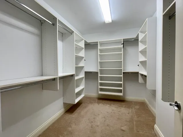 a view of walk in closet with empty racks