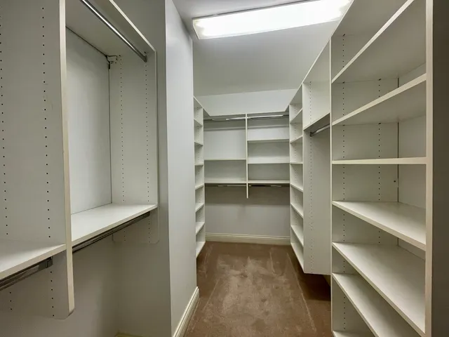 a view of walk in closet with empty racks