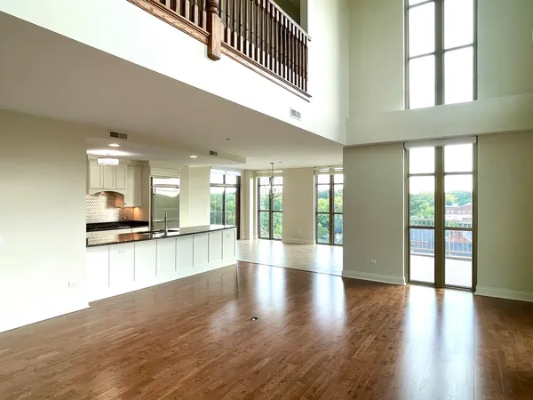 a hallway with wooden floor and a kitchen