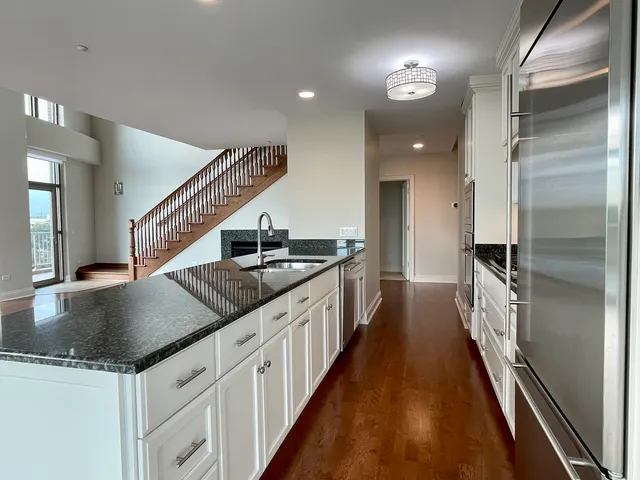 a kitchen with granite countertop a sink and a refrigerator