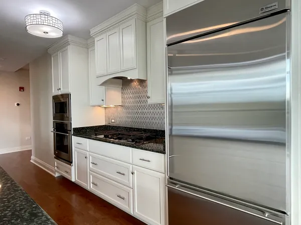 a kitchen with white cabinets and appliances