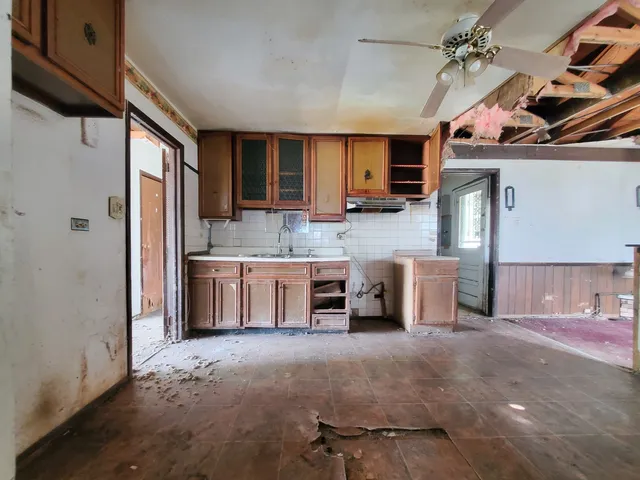 a kitchen with kitchen island granite countertop a sink cabinets and stainless steel appliances