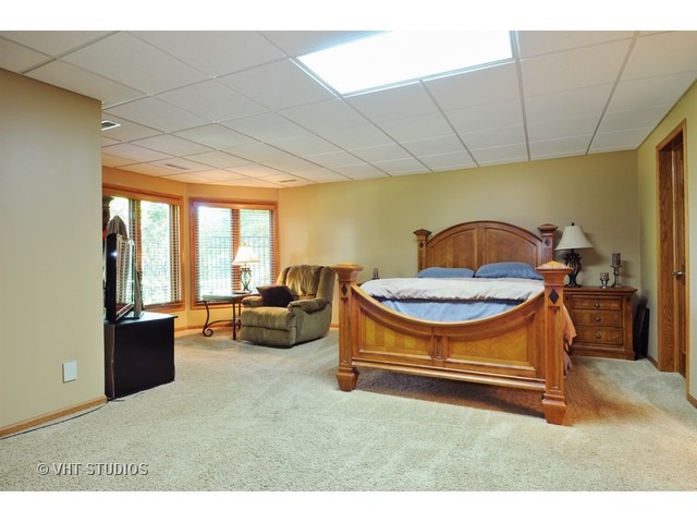 3737 Wolf Road Oswego, IL 60543 - Photo 22 of 25 a living room with furniture a flat screen tv and a table