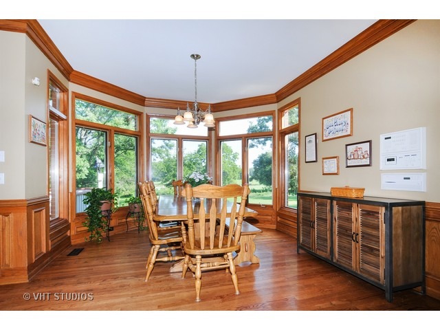 3737 Wolf Road Oswego, IL 60543 - Photo 7 of 25 a dining room with wooden floor a chandelier a glass table and chairs