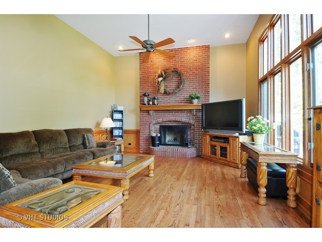3737 Wolf Road Oswego, IL 60543 - Photo 10 of 25 a living room with furniture a fireplace and a flat screen tv