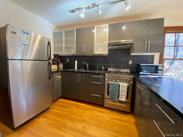 a kitchen with a refrigerator sink and cabinets