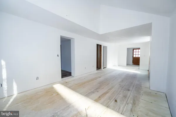 a view of a big room with wooden floor and windows
