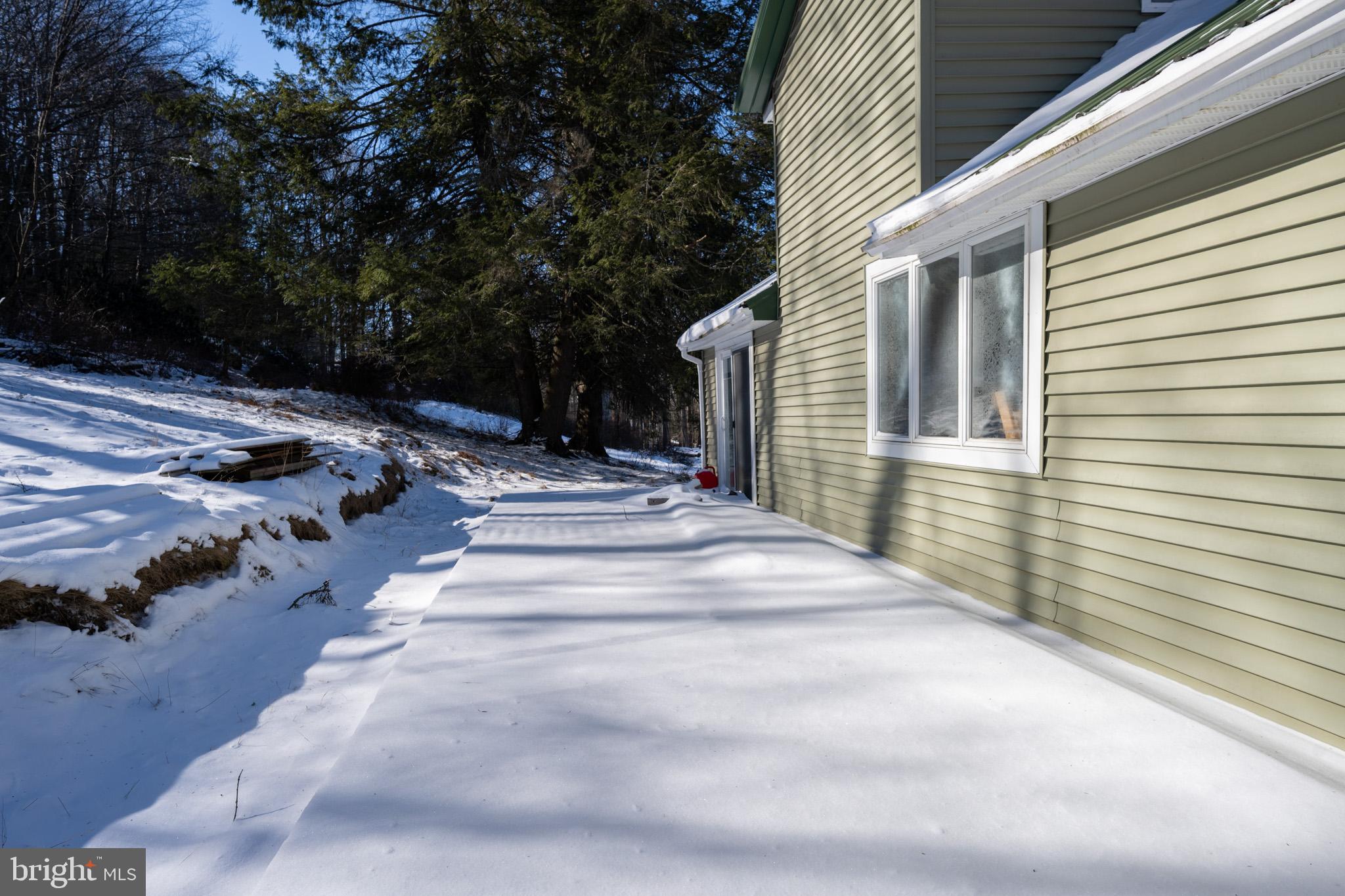 43 Sloan Tract Road Oakland, MD 21550 - Photo 7 of 47 Sunlit snow blankets a charming home exterior.