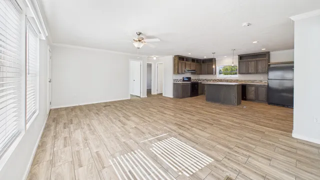 a large kitchen with kitchen island a sink wooden floor and stainless steel appliances
