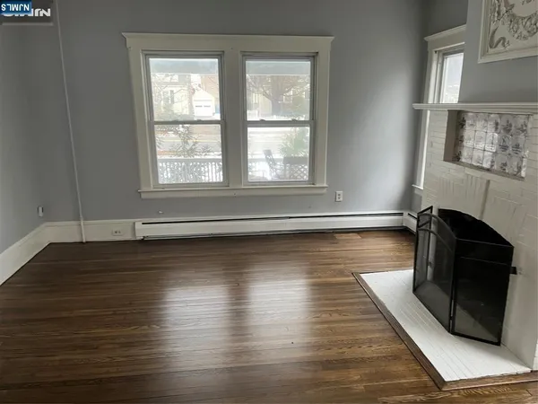a view of a room with wooden floor and a floor to ceiling window