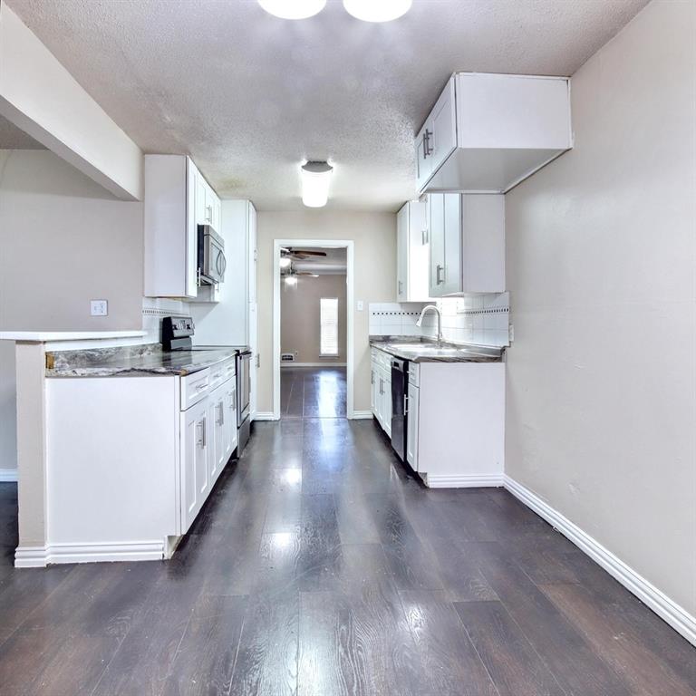 9914-9916 Brockbank Drive Dallas, TX 75220 - Photo 6 of 12 a kitchen with stainless steel appliances a sink wooden floor cabinets and a dining table