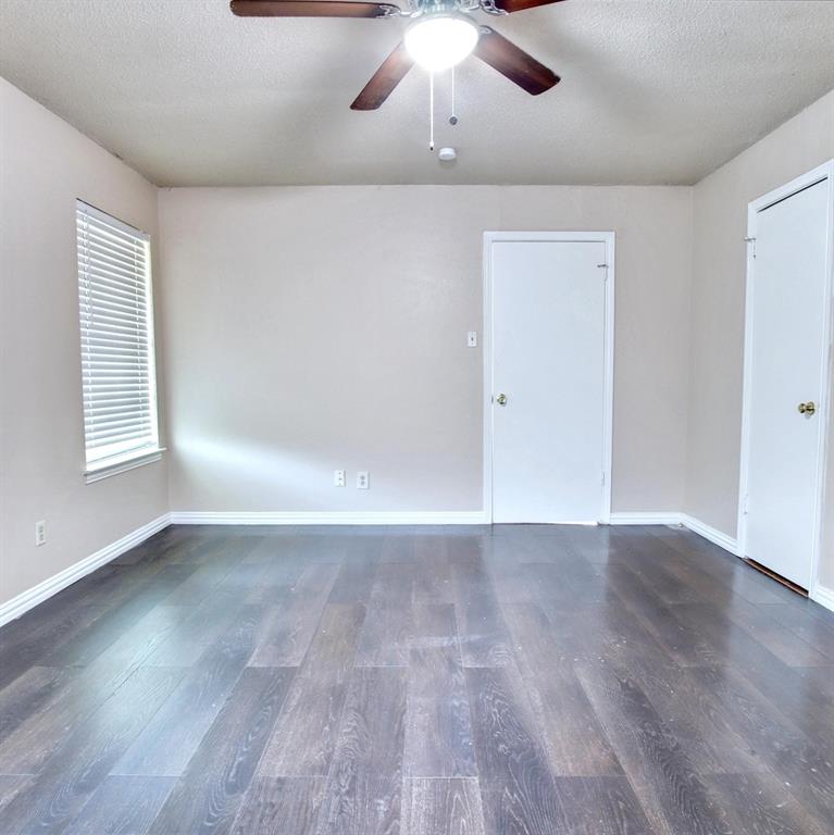 9914-9916 Brockbank Drive Dallas, TX 75220 - Photo 7 of 12 an empty room with wooden floor chandelier fan and windows