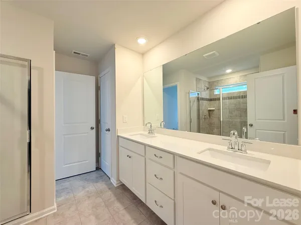 a spacious bathroom with a double vanity sink mirror and double