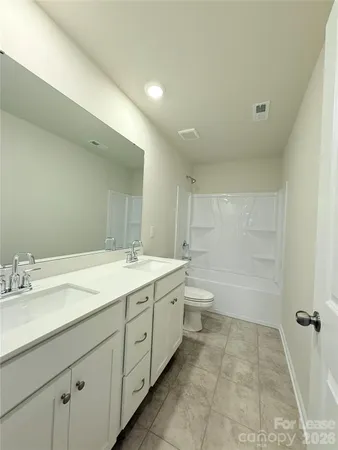 a spacious bathroom with a granite countertop sink a toilet and a bathtub
