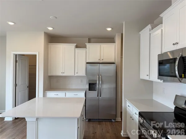 a kitchen with kitchen island a counter top space stainless steel appliances and cabinets