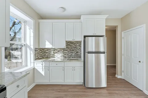 a kitchen with a refrigerator sink and cabinets