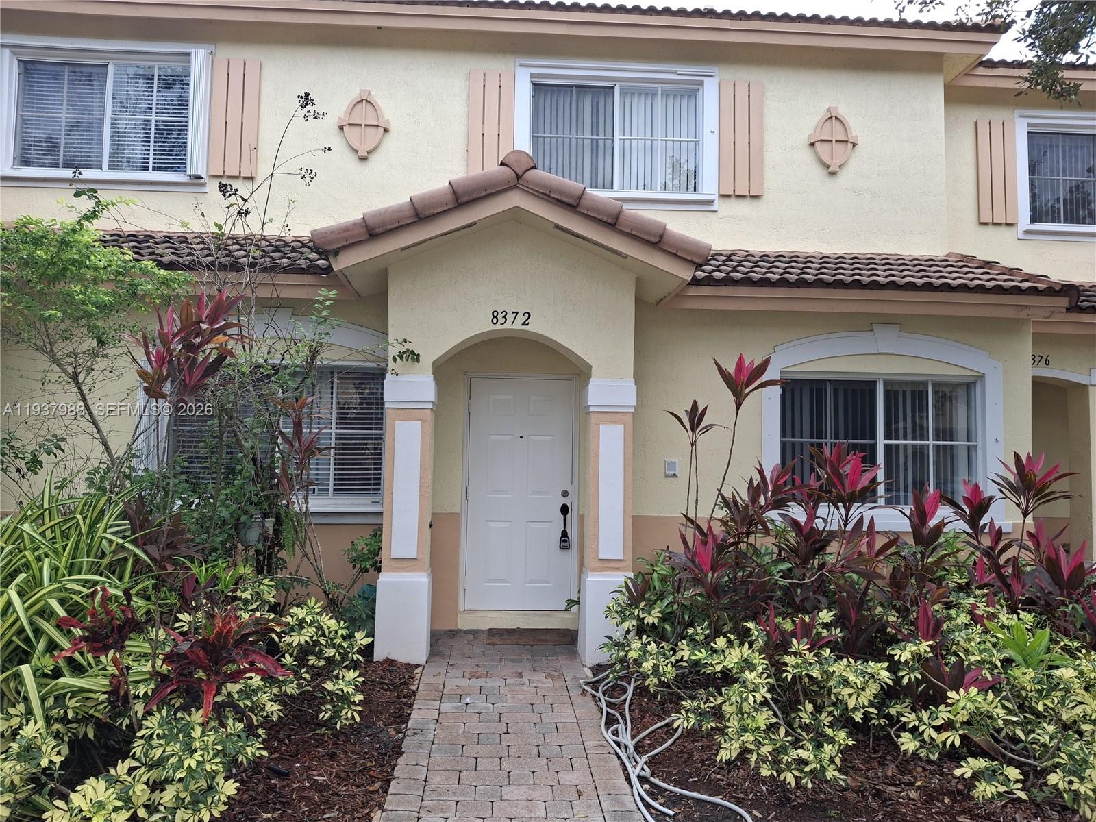 8372 Southwest 25th Court, Unit 102 Miramar, FL 33025 - Photo 5 of 11 a front view of a house with a flower garden
