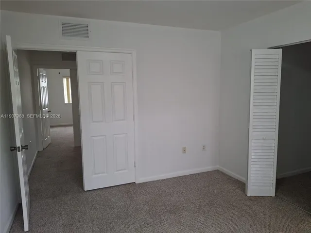 a view of a hallway with wooden floor and a cabinet