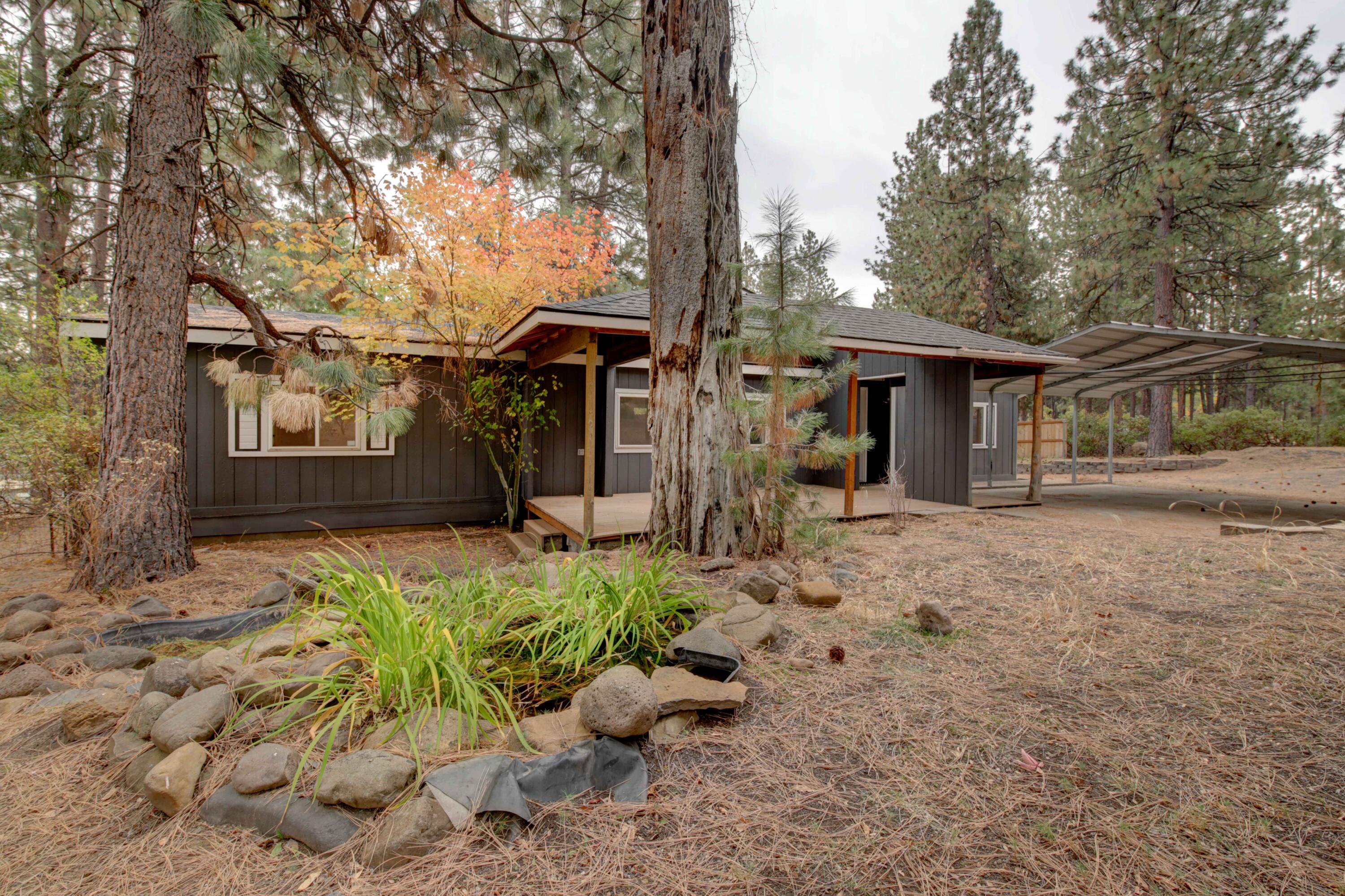 60184 Crater Road Bend, OR 97702 - Photo 2 of 29 Front yard features a water feature, trex deck, paver patio, and pine trees.