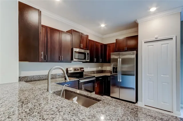 a kitchen with stainless steel appliances granite countertop a refrigerator and a sink