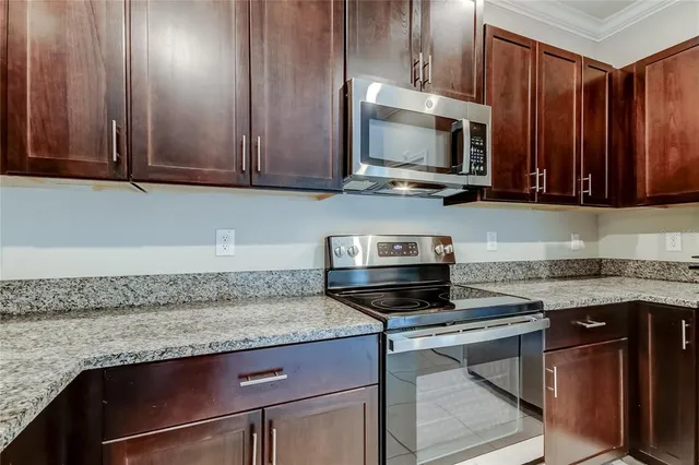 a kitchen with granite countertop wood cabinets and stainless steel appliances
